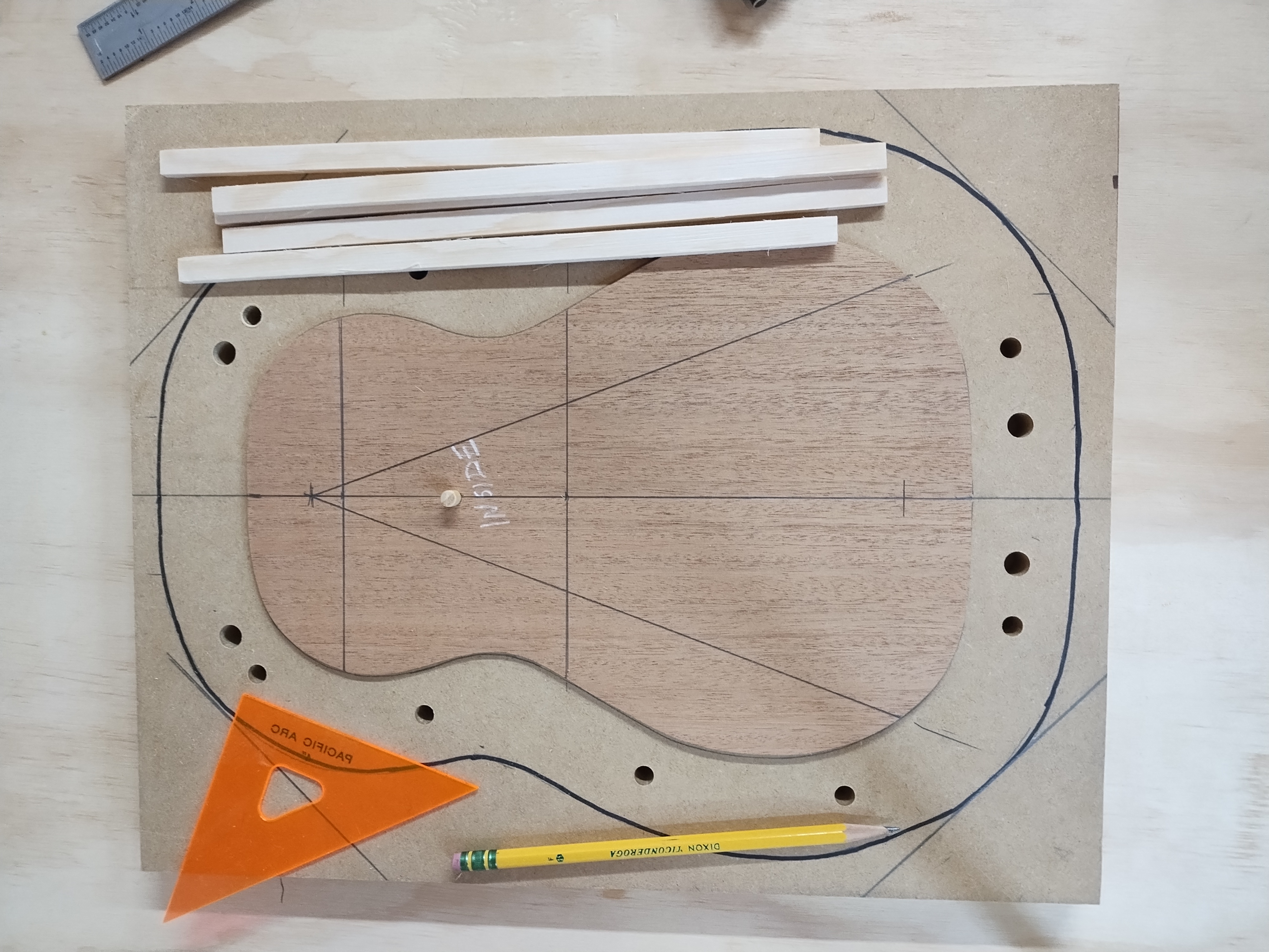 Ukulele soundboard marked with bracing layout lines